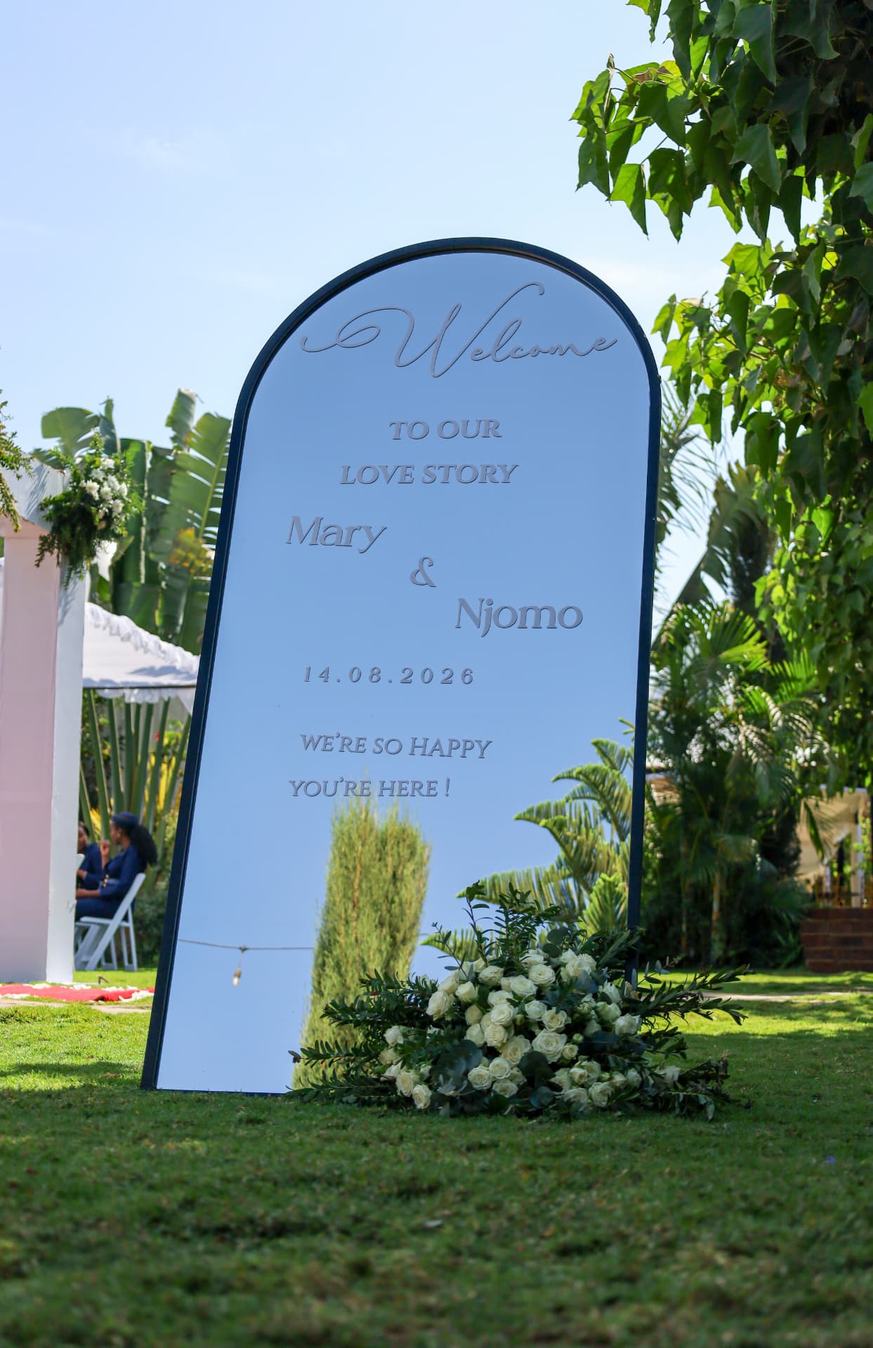 Floral mirror welcome sign standing on the garden lawn