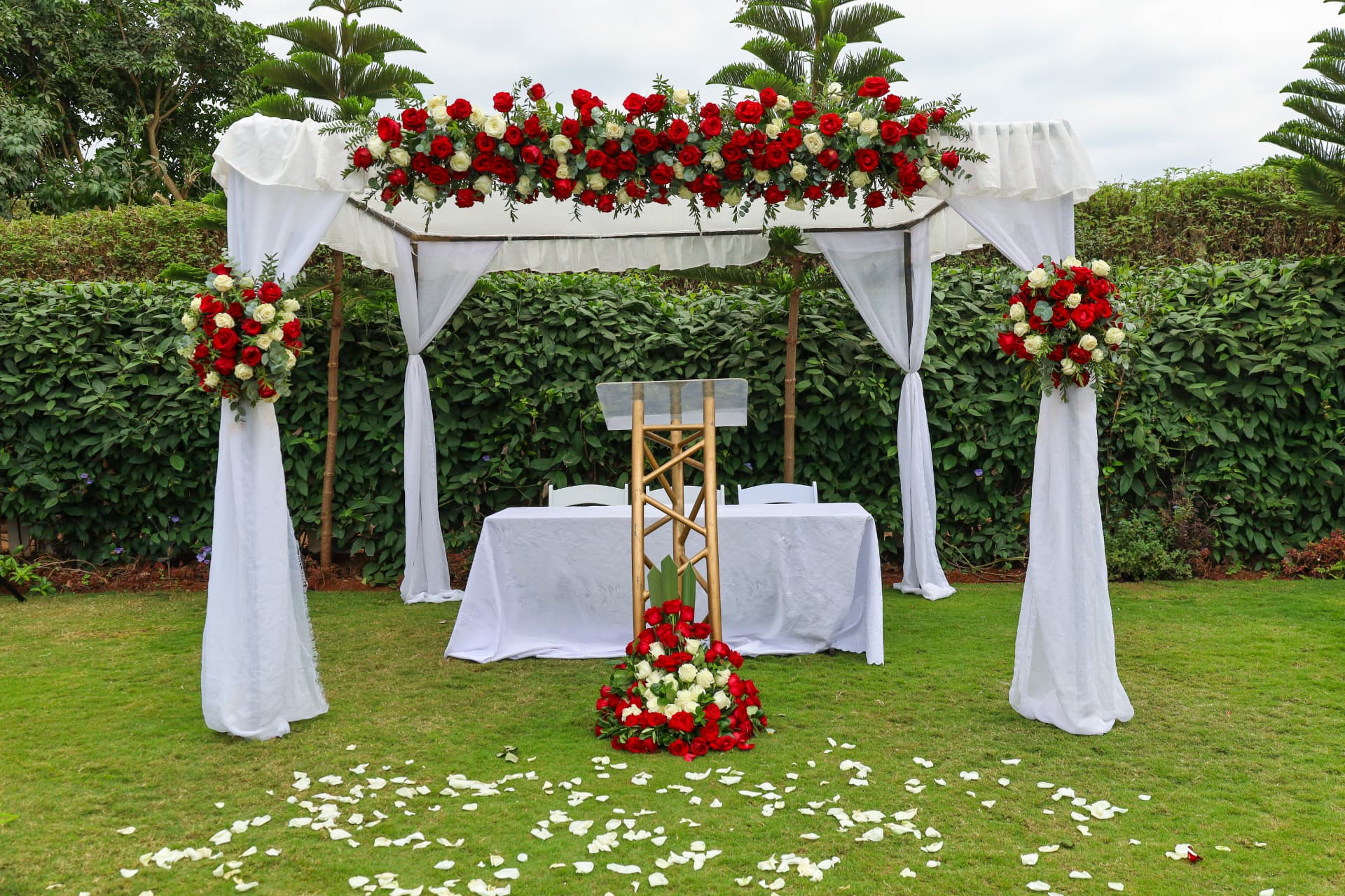 Outdoor ceremony setting decorated with red and white roses
