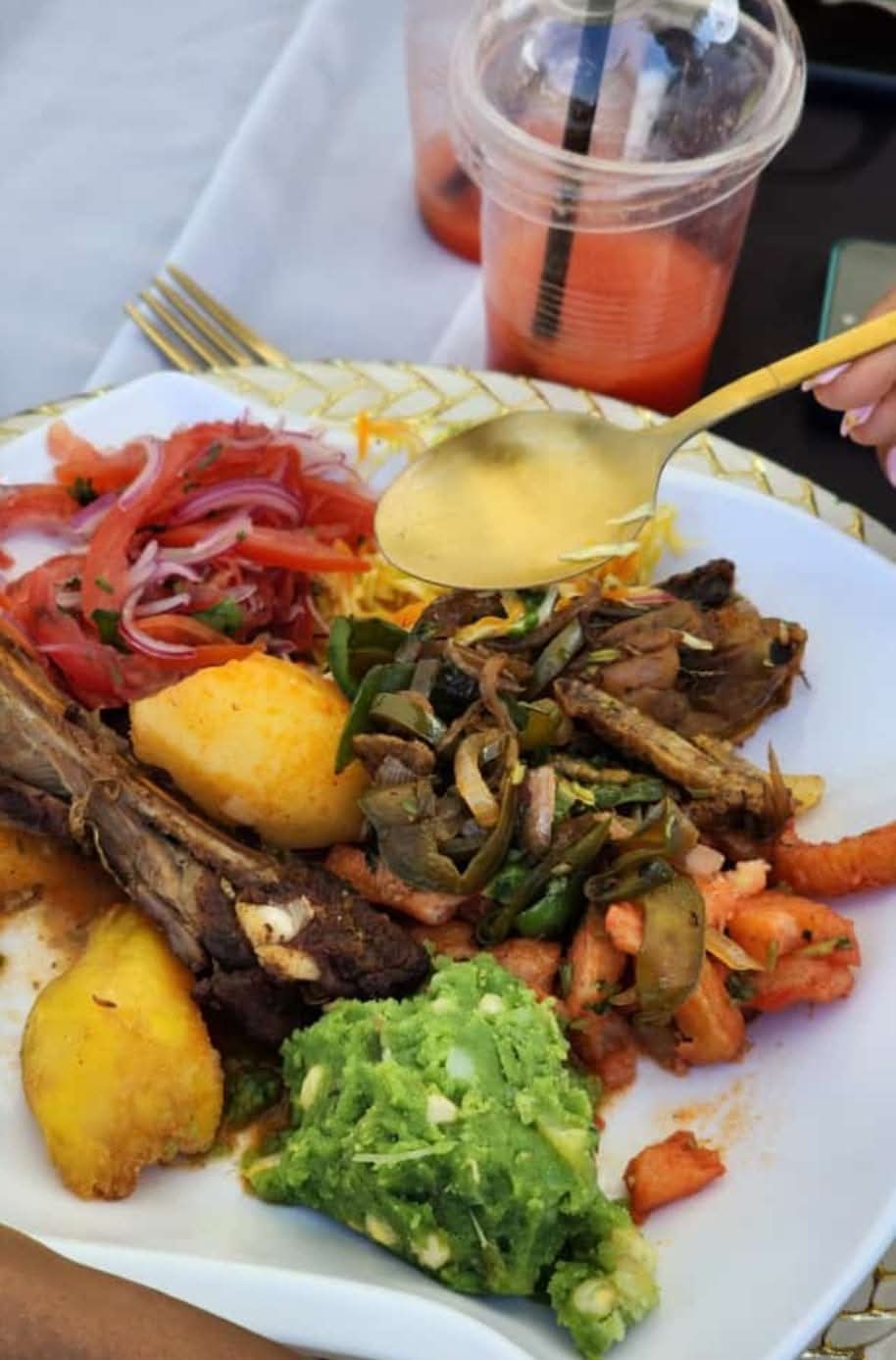 Freshly served meal with potatoes, vegetables and a cold drink